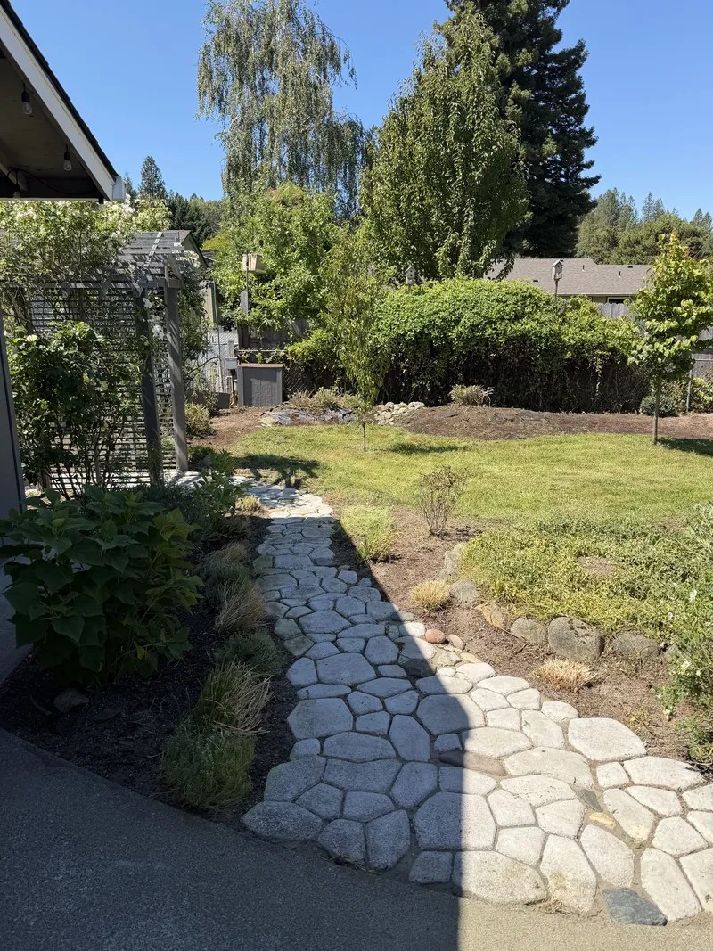 The same flagstone path fully exposed, with the beds mulched and the lawn mowed, after Hilltop Landscaping restored the yard in Southern Oregon