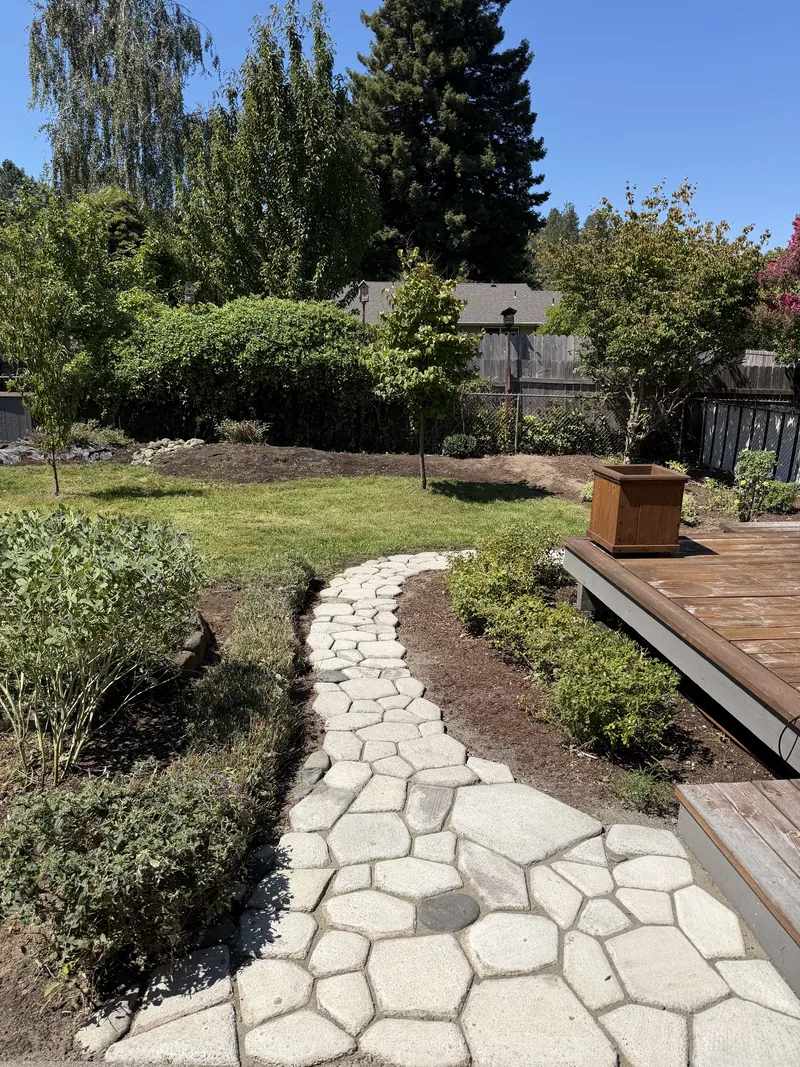The same backyard after Hilltop Landscaping mowed the lawn, edged the stone path and mulched the planting beds in Southern Oregon